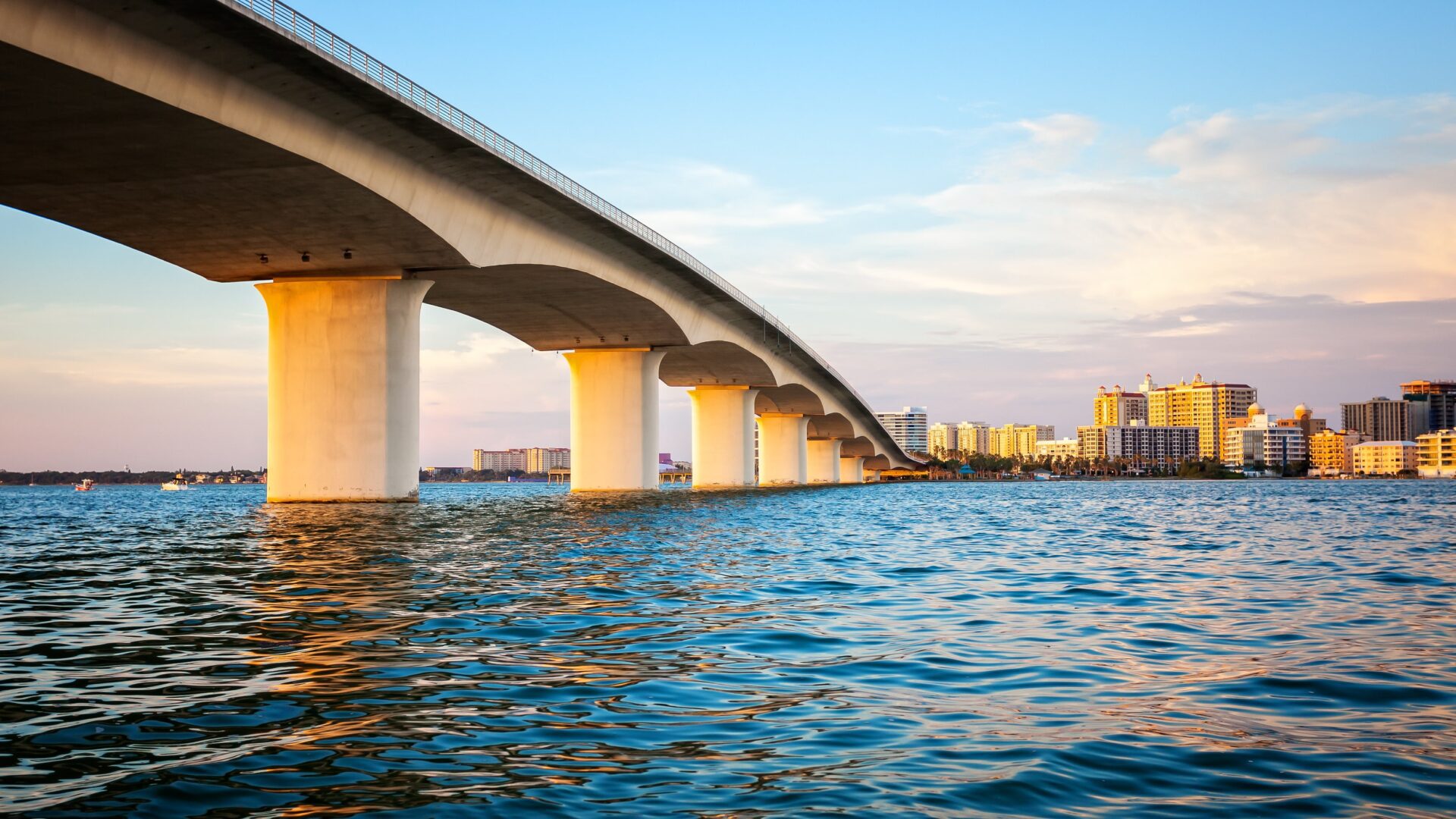 A large bridge over the water leading to a city